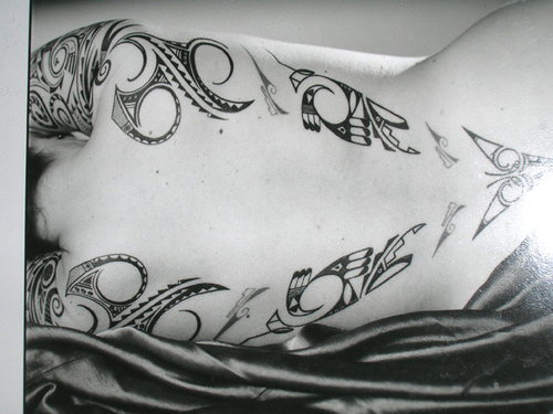 Black and white style tattoo on woman's back